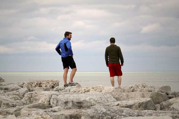 David Chrisinger, left, and Brett Foley hike along Lake Michigan.